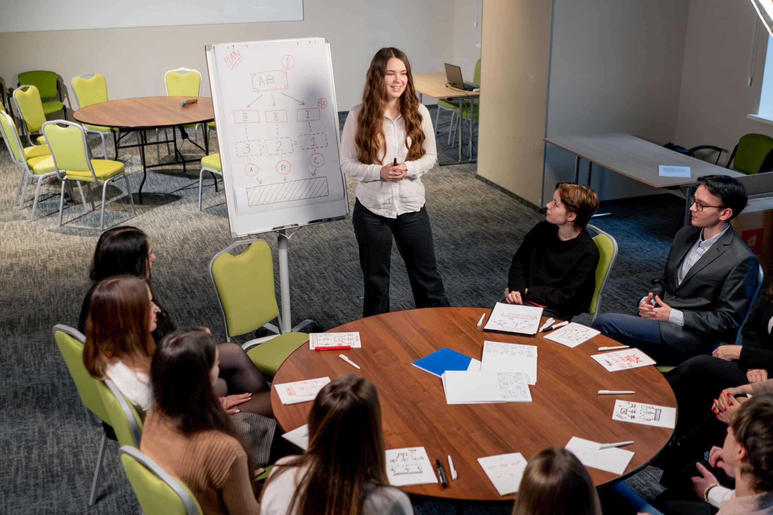 business conference or meeting at the hotel the girl on the flipchart shows the development plan for the company